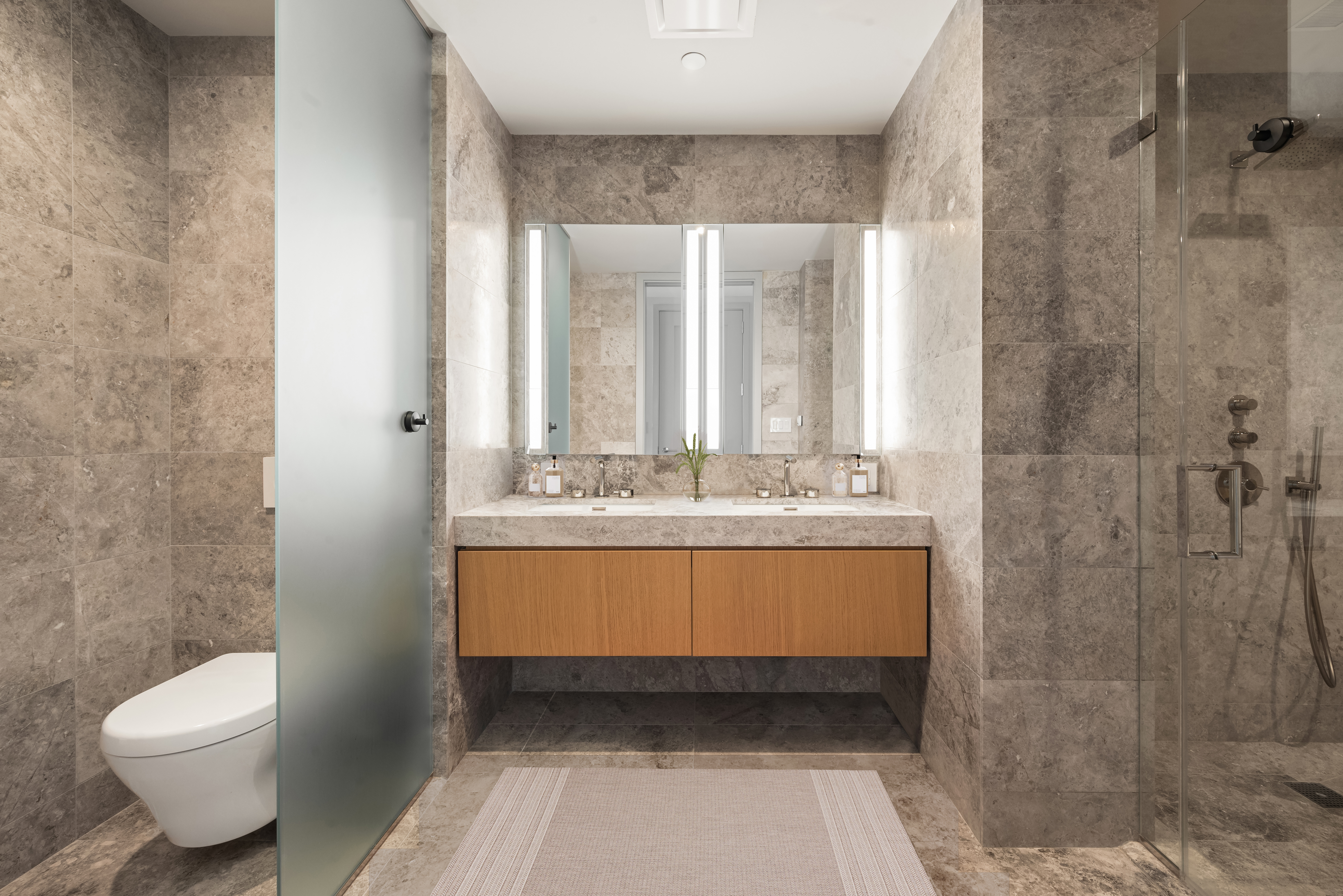 1059 3rd Avenue, Unit 18B Manhattan, NY 10065 - Photo 9 of 11 a bathroom with a sink a toilet and shower