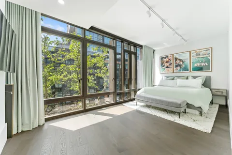 a spacious bedroom with a large bed and a large window