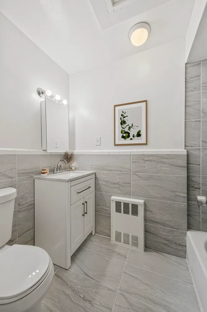 a bathroom with a toilet a sink and mirror