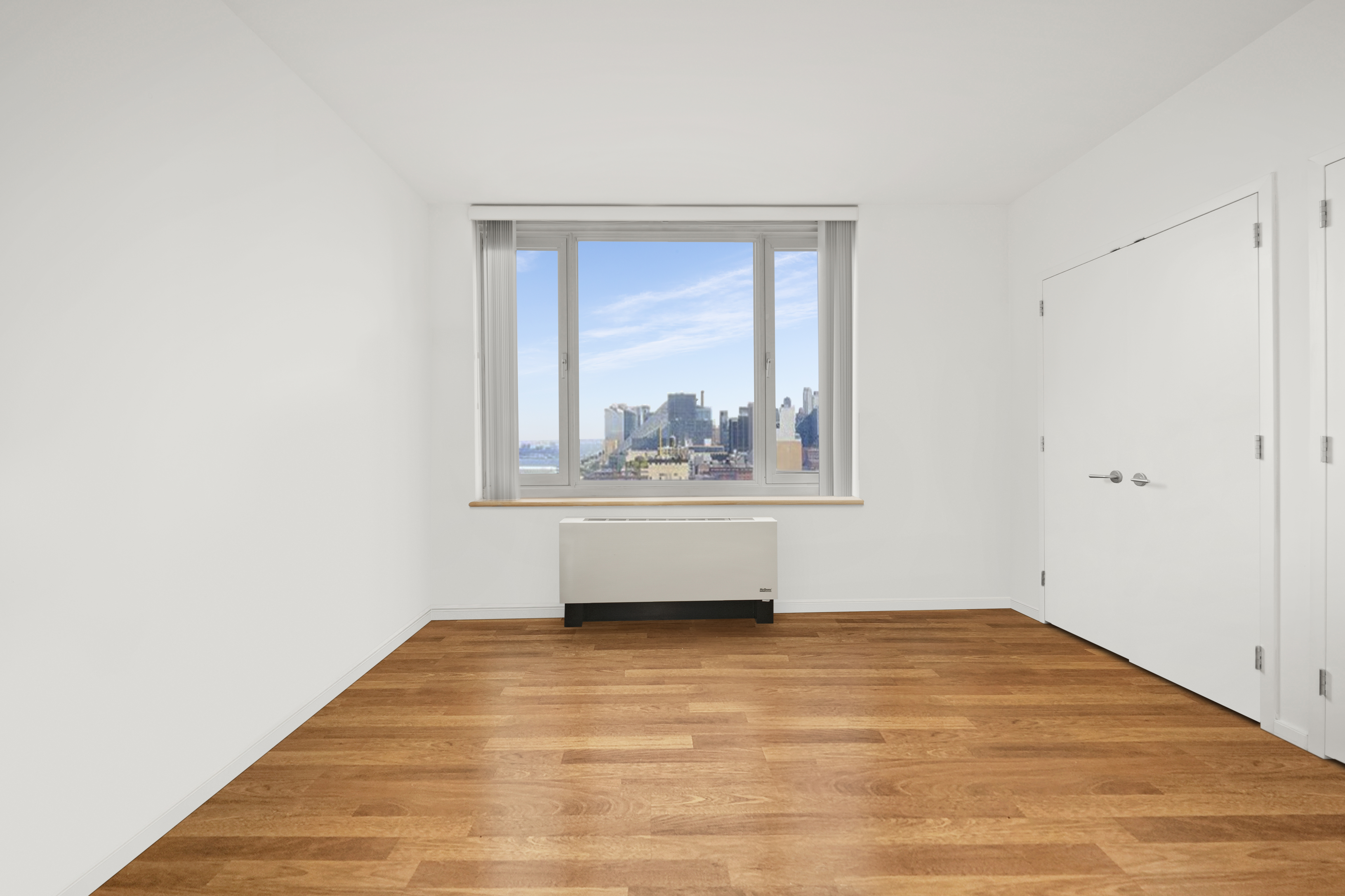 635 West 42nd Street, Unit 12D Manhattan, NY 10036 - Photo 9 of 18 a view of an empty room with wooden floor and a window