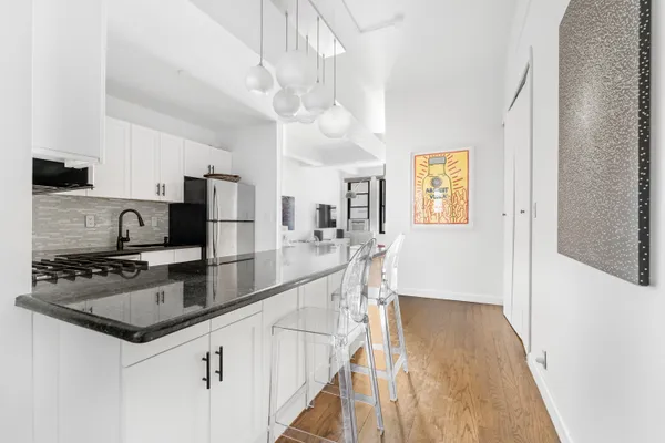 a kitchen with stainless steel appliances granite countertop a sink a stove top oven a counter space and cabinets