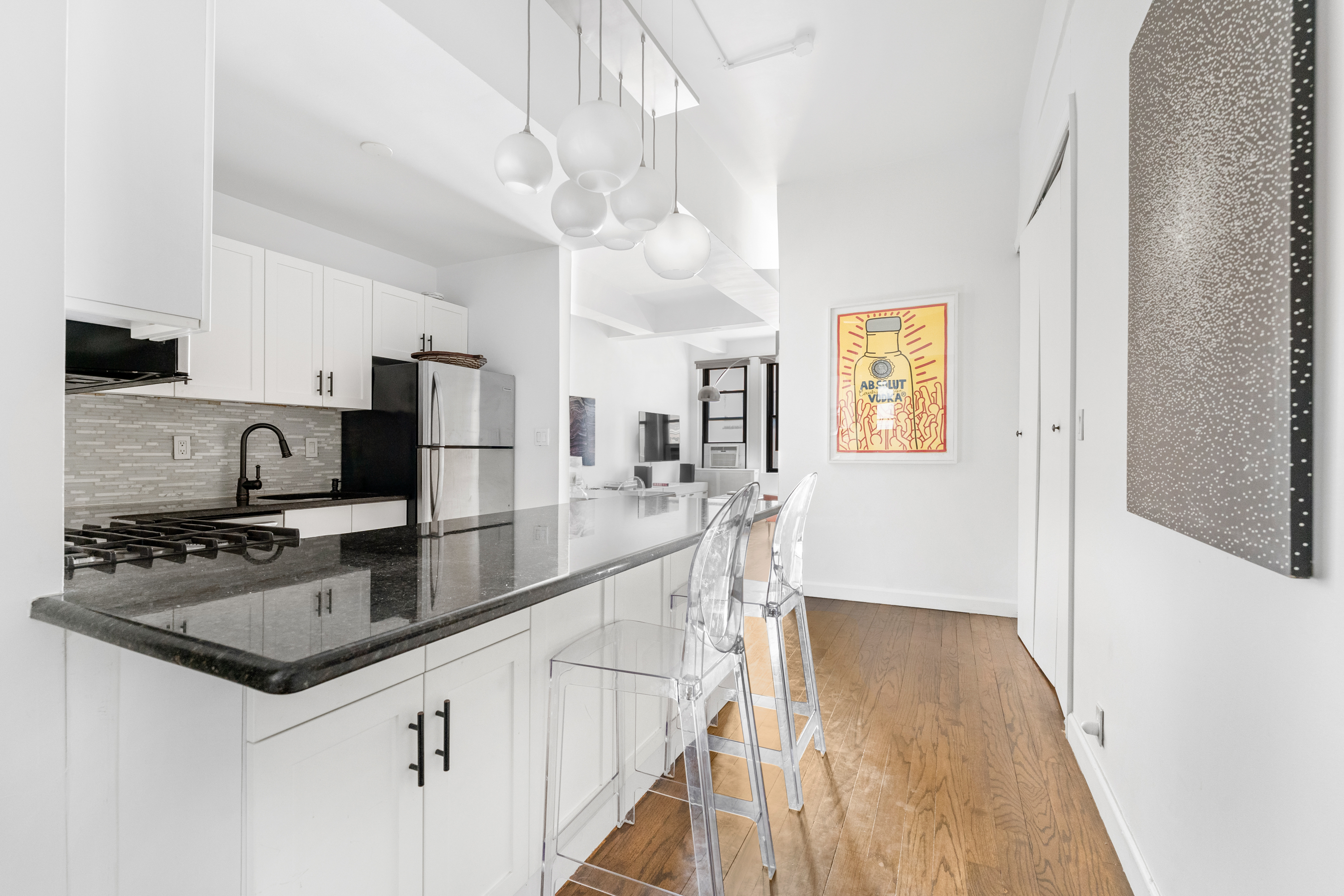 315 7th Avenue, Unit 5C Manhattan, NY 10001 - Photo 4 of 7 a kitchen with stainless steel appliances granite countertop a sink a stove top oven a counter space and cabinets