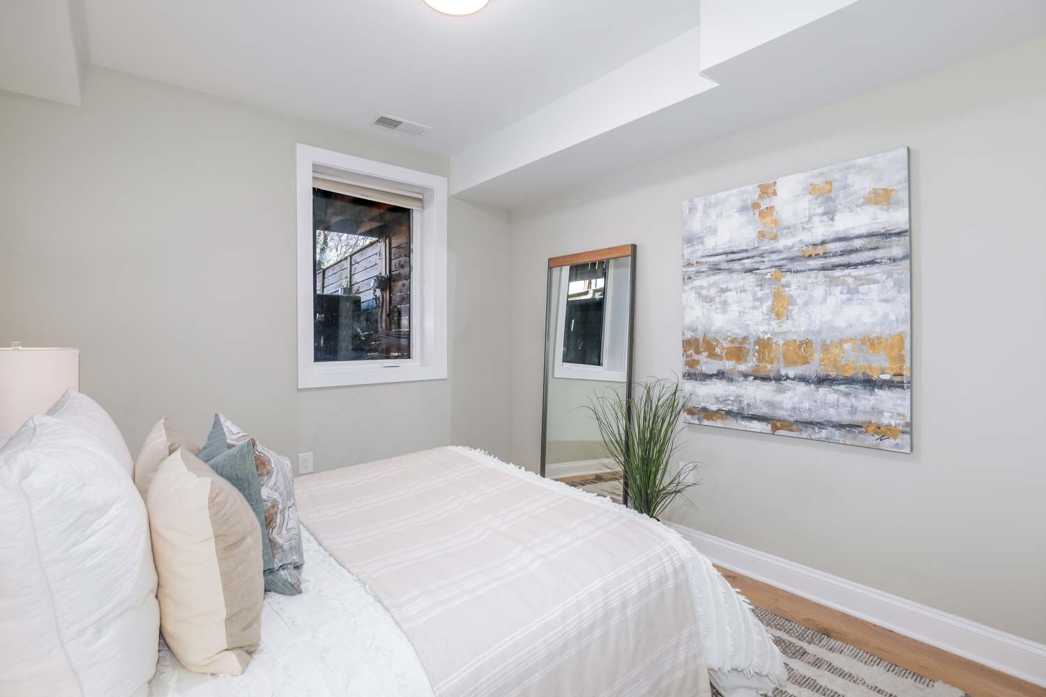 a bedroom with a bed and a painting on the wall