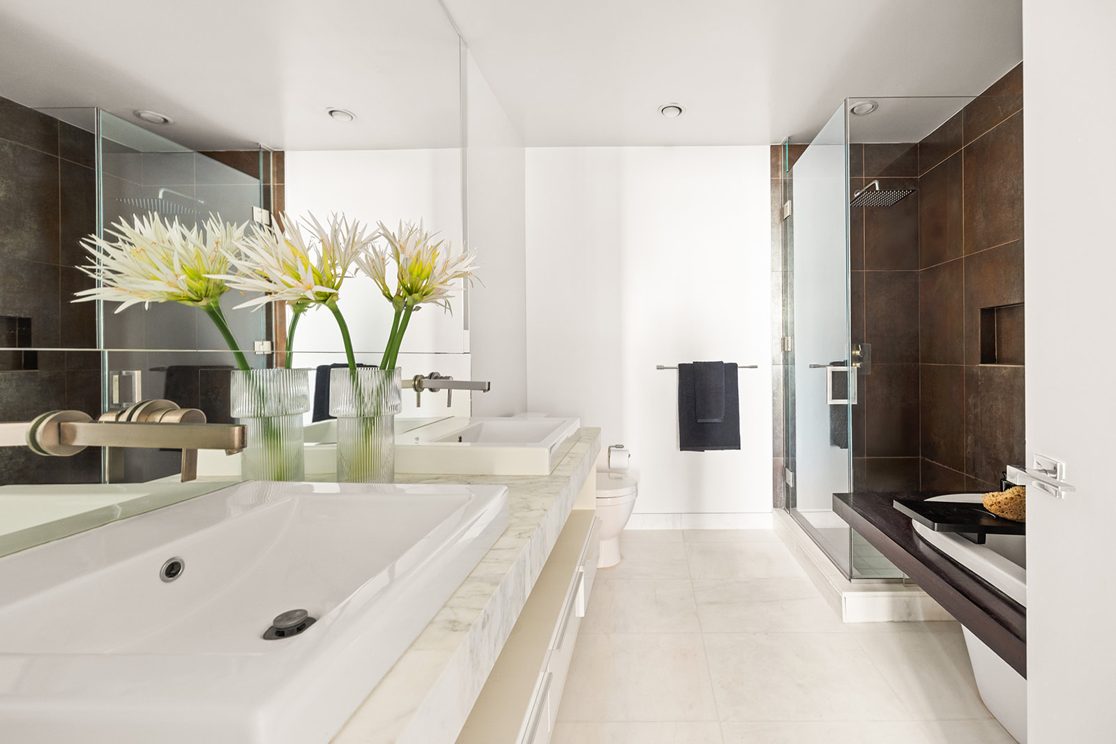 133 West 22nd Street, Unit 8G Manhattan, NY 10011 - Photo 6 of 16 a bathroom with a double vanity sink a mirror and a shower