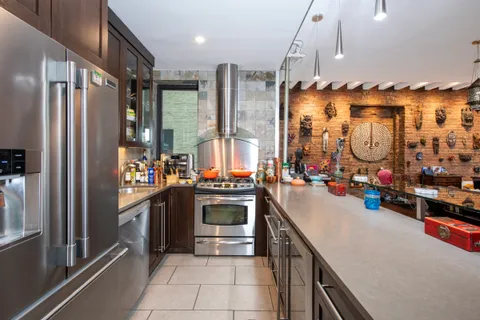 a kitchen with stainless steel appliances granite countertop a sink and a refrigerator