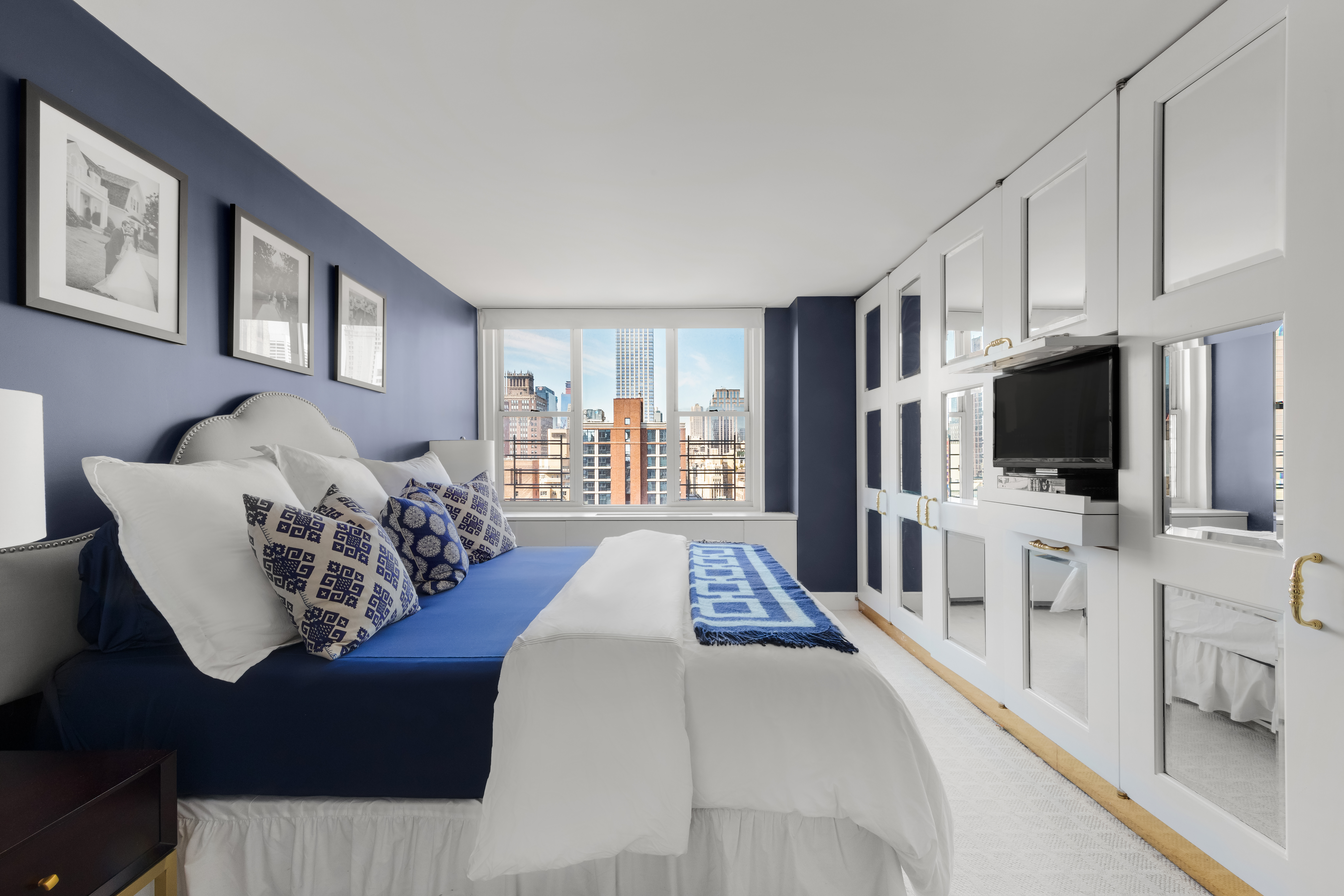 137 East 36th Street, Unit 21F Manhattan, NY 10016 - Photo 9 of 20 a large bedroom with a bed and a flat screen tv