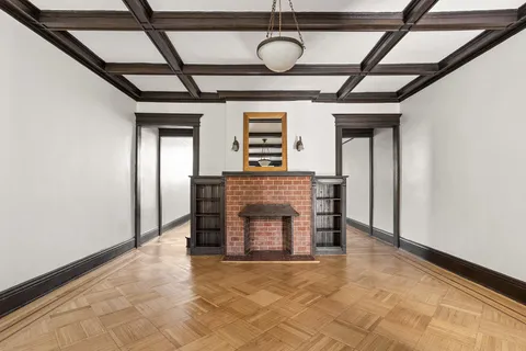 a view of an empty room with a fireplace and a window