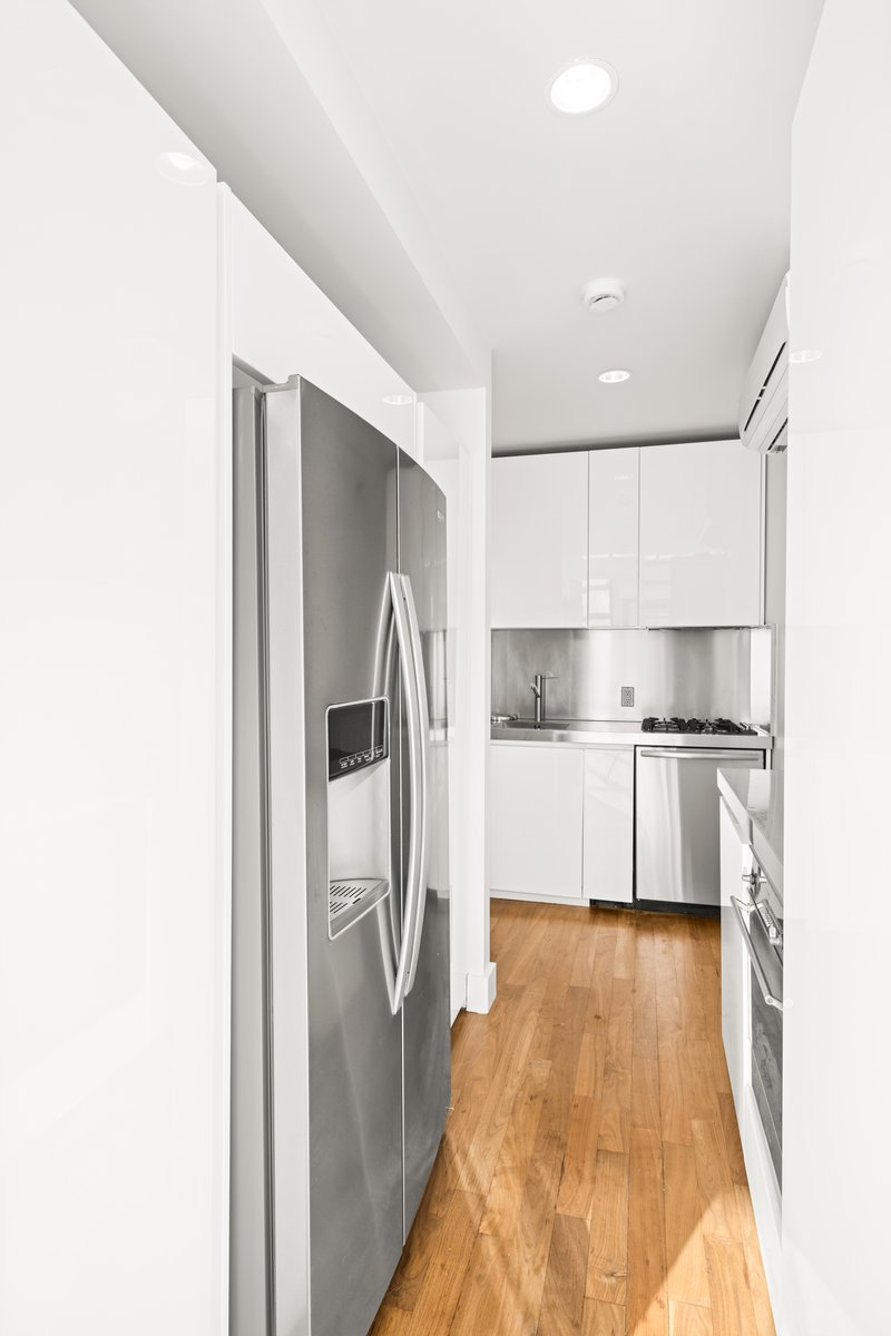 23 East 67th Street, Unit PH6 Manhattan, NY 10065 - Photo 3 of 7 a kitchen with stainless steel appliances granite countertop a refrigerator and a stove