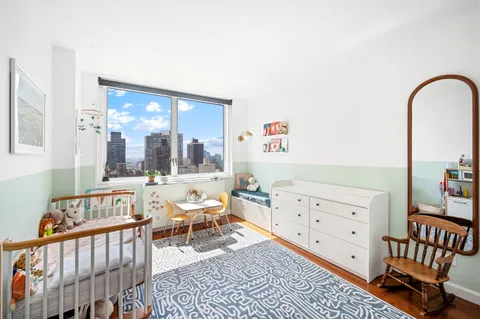 a bedroom with furniture and a large window