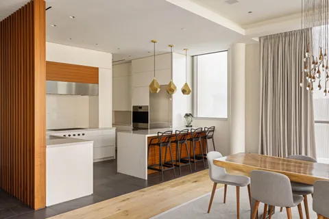 a kitchen with stainless steel appliances granite countertop a stove top oven a sink with a dining table and chairs
