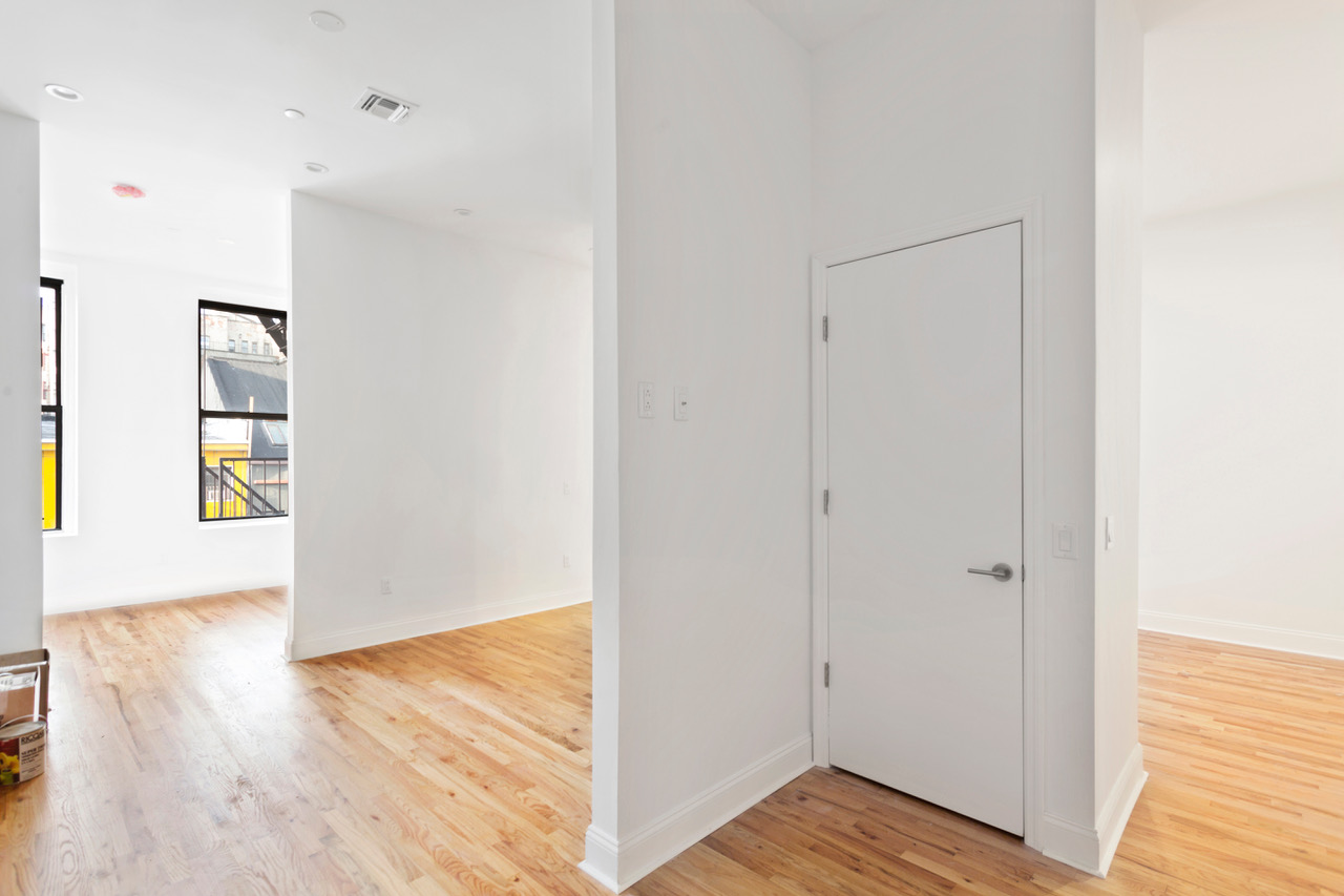 281 Grand Street, Unit 2R Manhattan, NY 10002 - Photo 9 of 11 a view of an empty room with closet and wooden floor