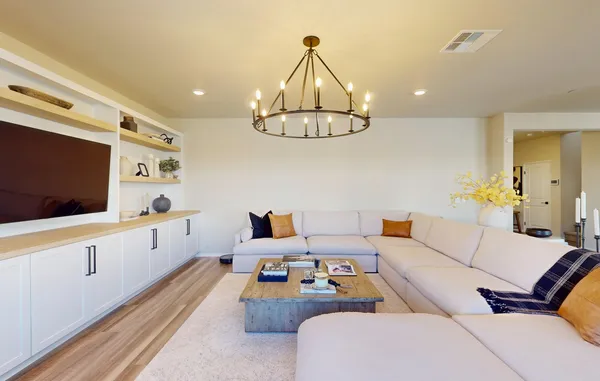 a living room with furniture chandelier and a table