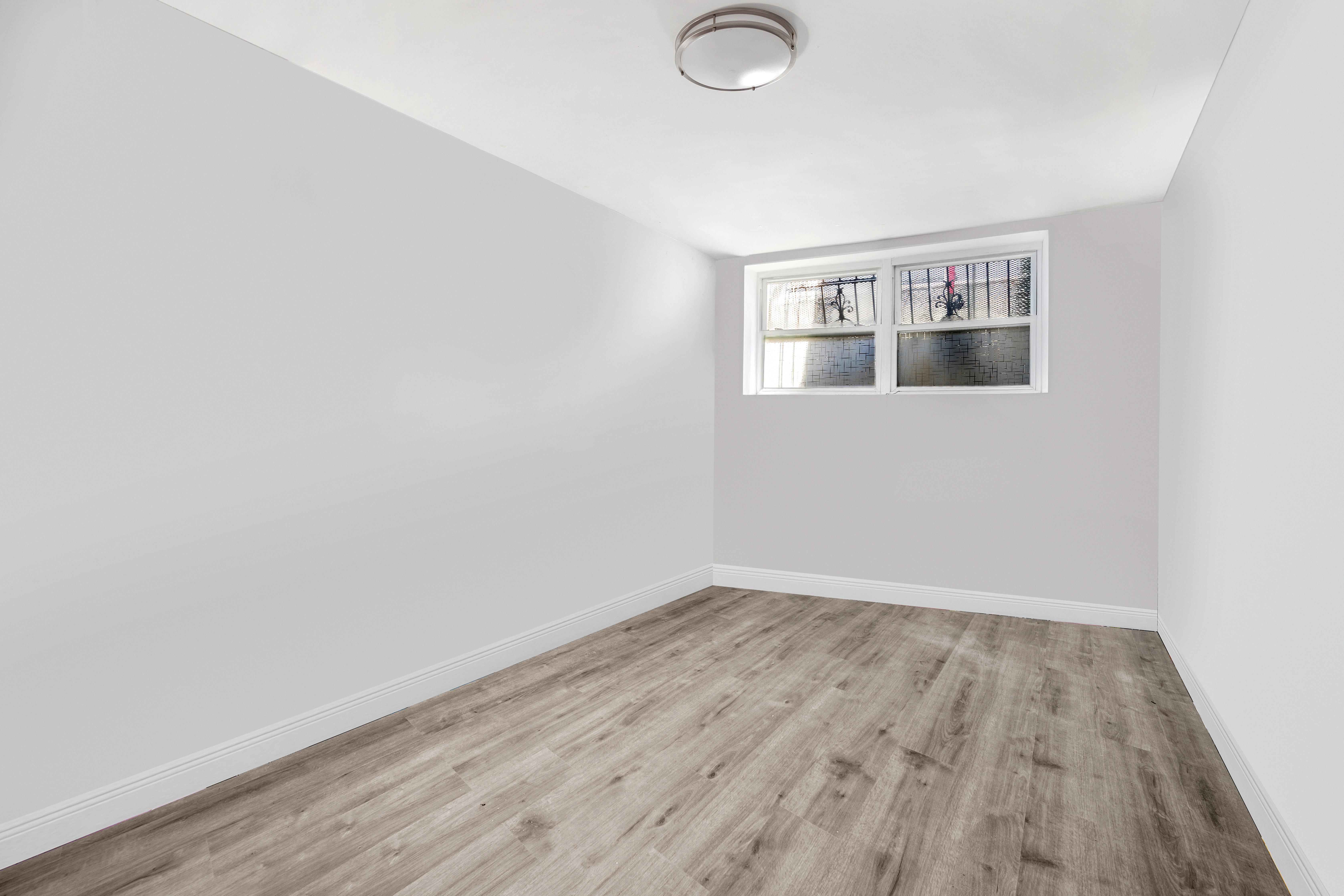 364 Chauncey Street Brooklyn, NY 11233 - Photo 6 of 17 a view of a room with wooden floor and white walls