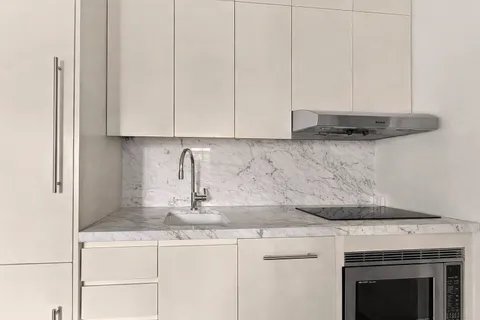 a kitchen with granite countertop white cabinets and a stove