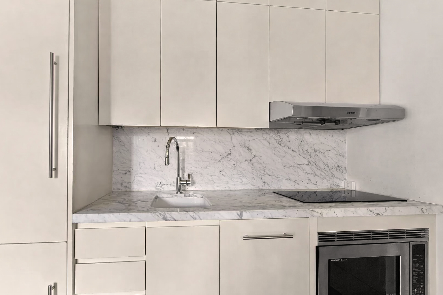 56 Jane Street, Unit 4B Manhattan, NY 10014 - Photo 3 of 5 a kitchen with granite countertop white cabinets and a stove