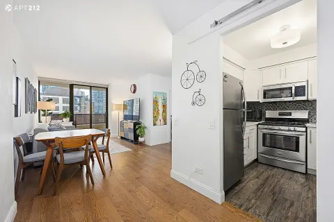 a kitchen with stainless steel appliances a stove a refrigerator and a dining table