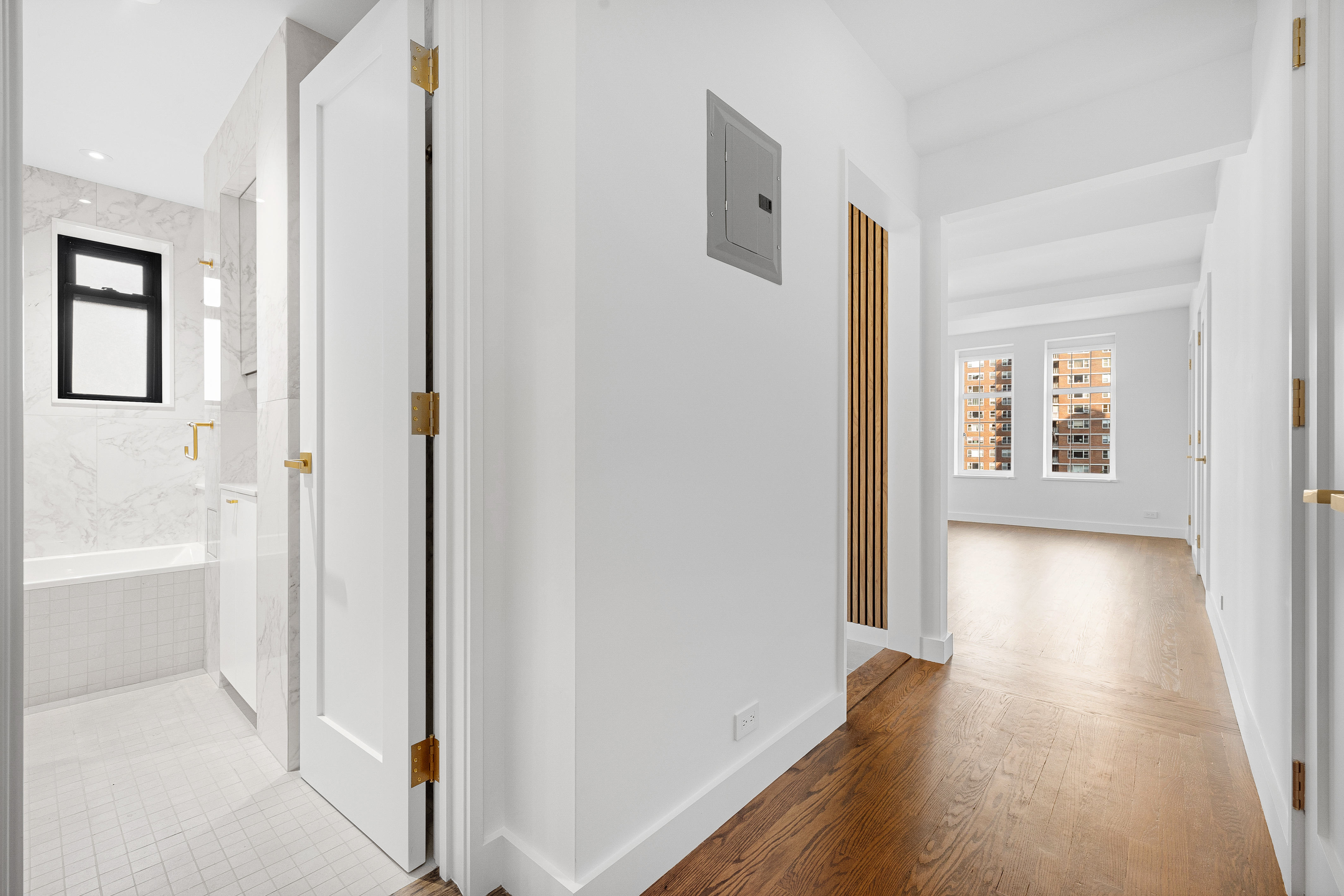 410 West 24th Street, Unit 8F Manhattan, NY 10011 - Photo 9 of 16 a view of a hallway with wooden floor and a living room