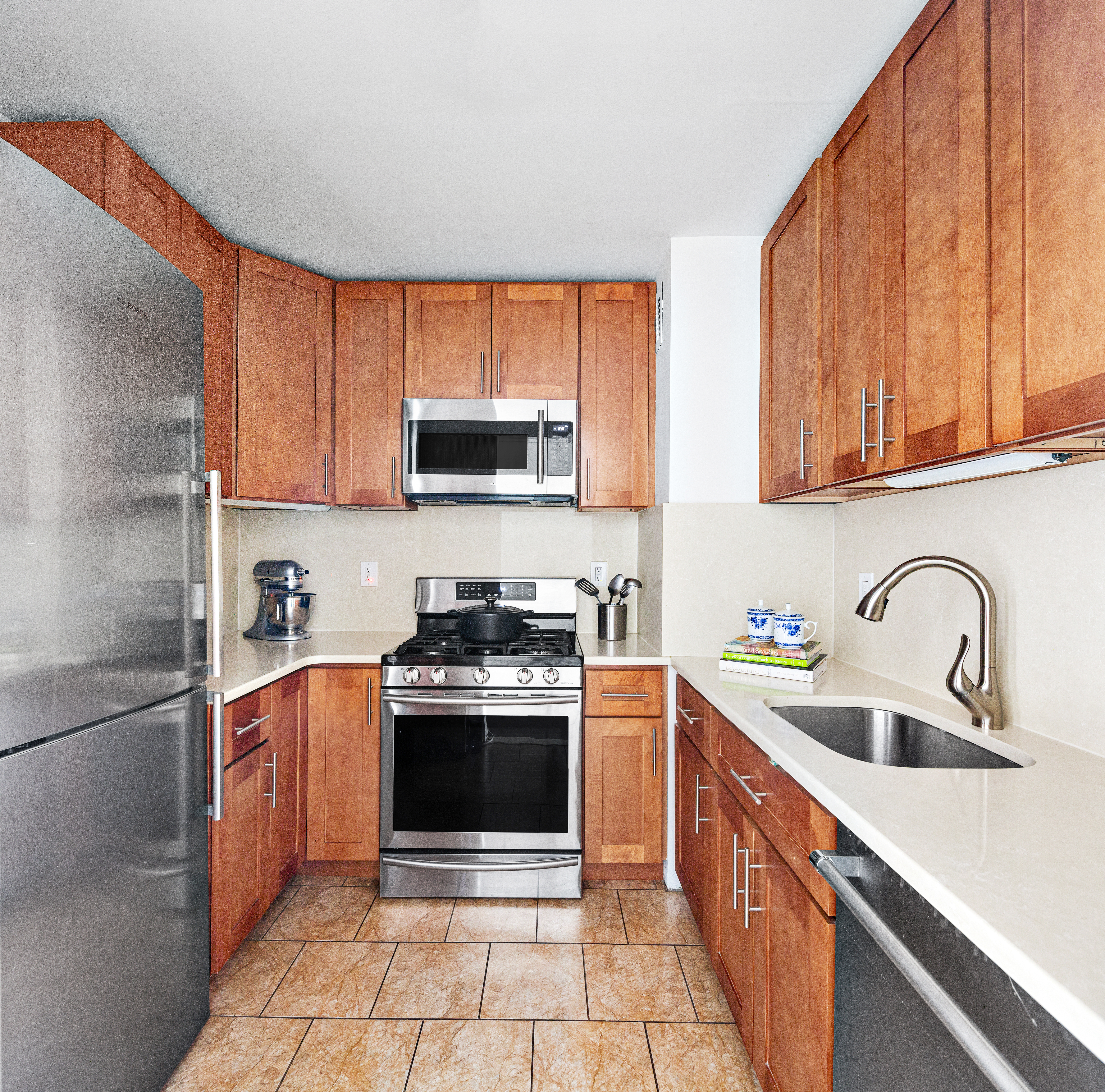 315 7th Avenue, Unit 9B Manhattan, NY 10001 - Photo 3 of 8 a kitchen with stainless steel appliances granite countertop a sink stove and refrigerator