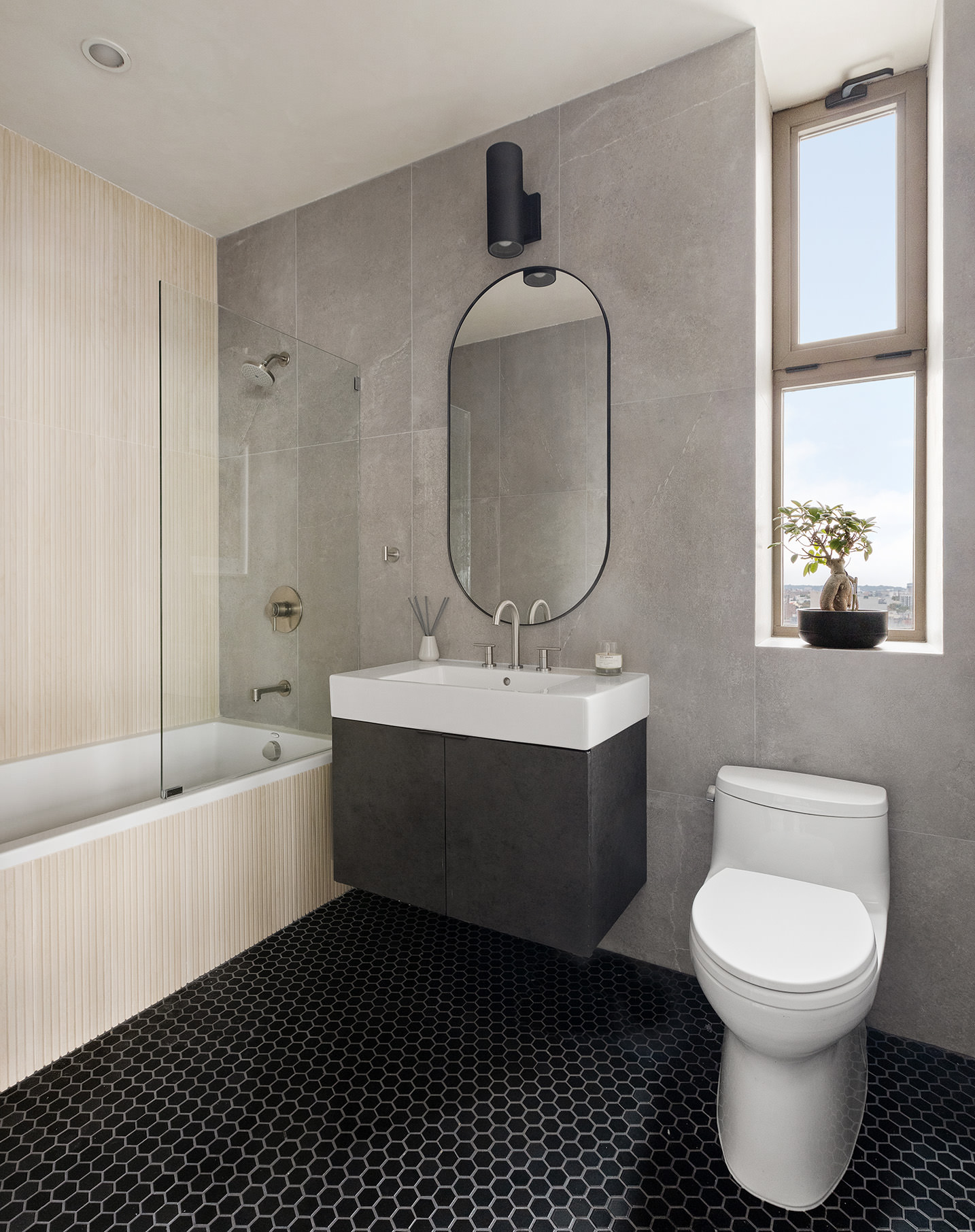 144 North 8th Street, Unit 12B Brooklyn, NY 11249 - Photo 13 of 15 a bathroom with a toilet a sink a mirror and bathtub