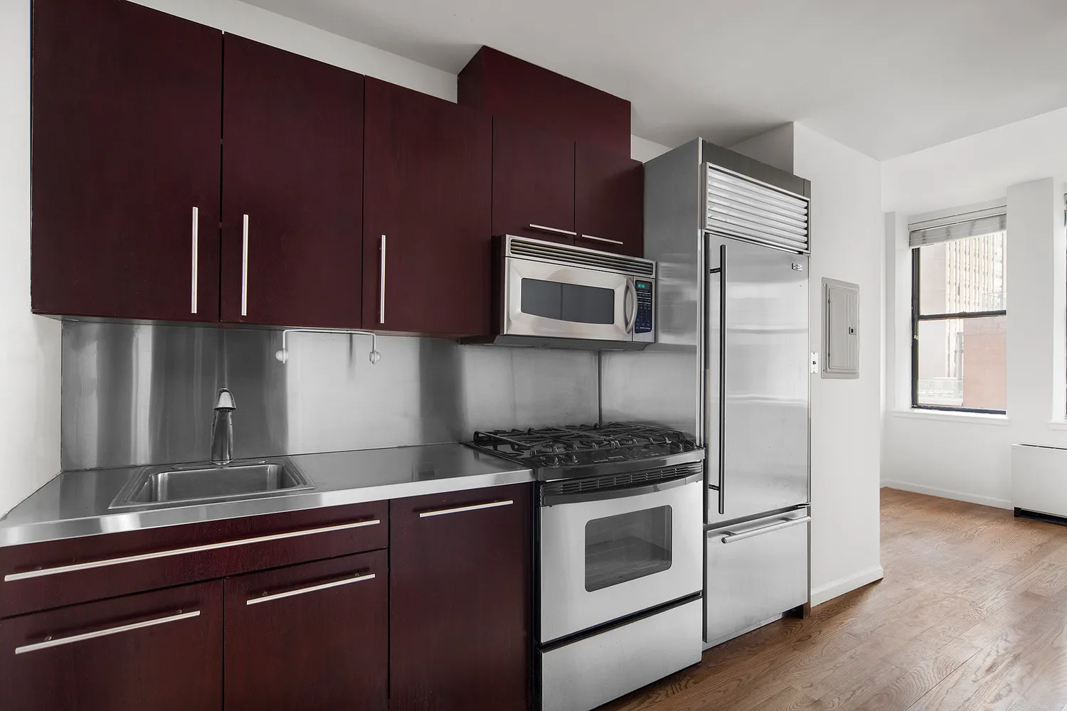 a kitchen with granite countertop cabinets stainless steel appliances and wooden floor