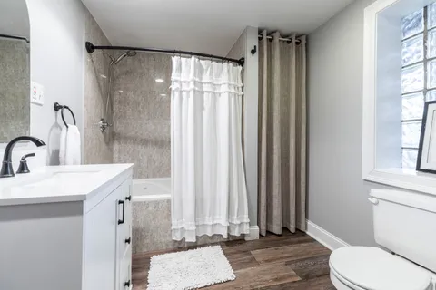 a bathroom with a sink a toilet and shower