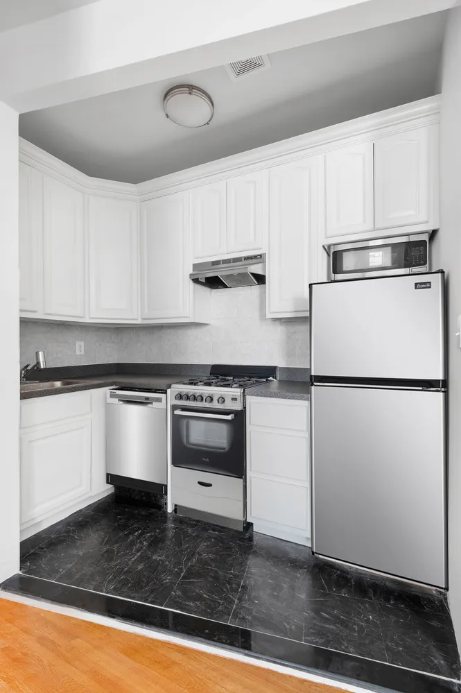 a kitchen with granite countertop a refrigerator and a stove