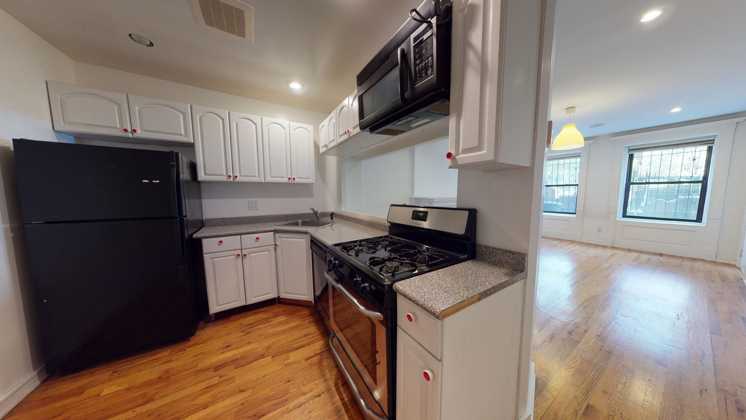 136 West 121st Street, Unit 1 Manhattan, NY 10027 - Photo 2 of 4 a kitchen with stainless steel appliances granite countertop a refrigerator a stove a sink dishwasher and a refrigerator with wooden floor