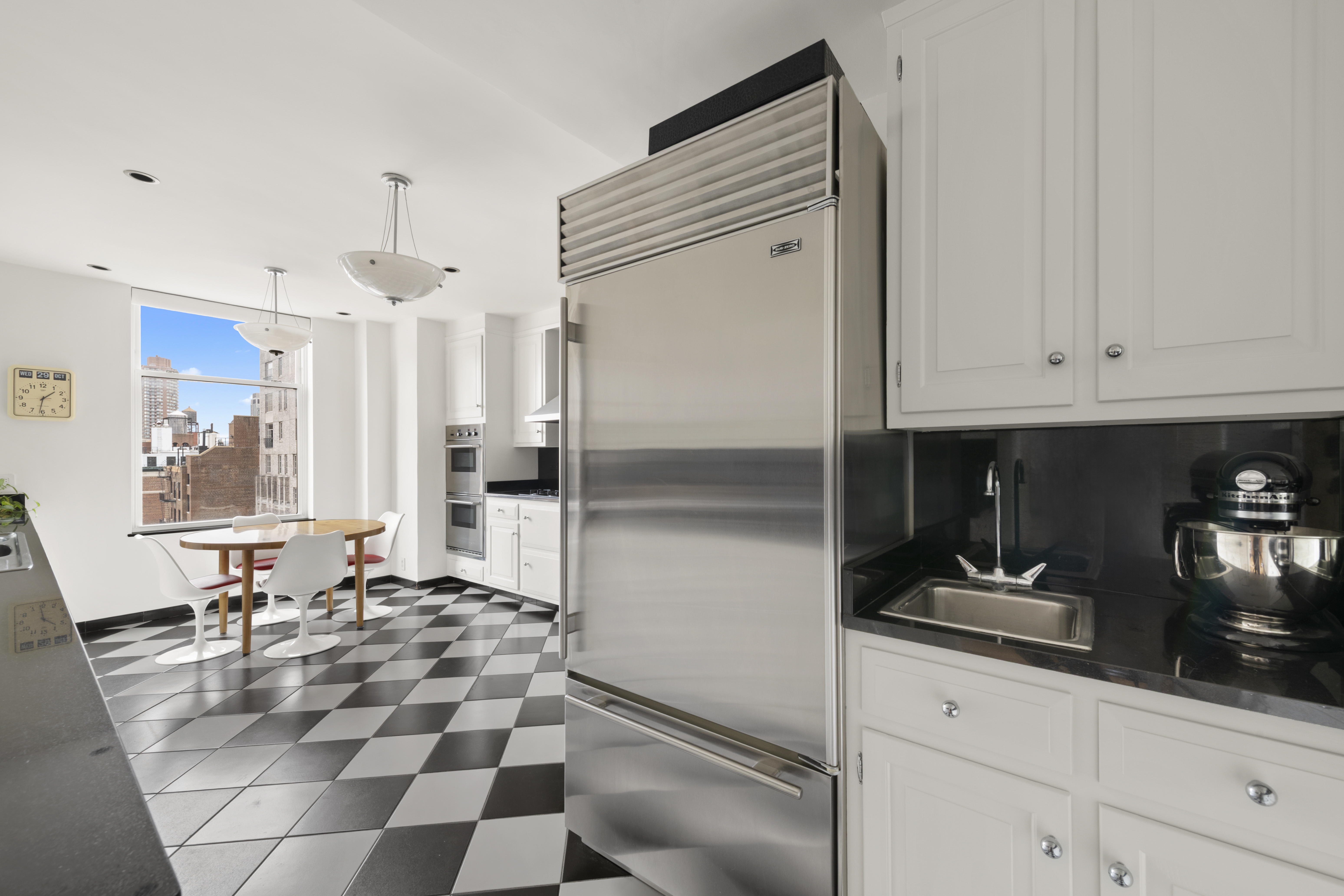 911 Park Avenue, Unit 14C Manhattan, NY 10075 - Photo 7 of 18 a kitchen with stainless steel appliances granite countertop a refrigerator and a sink