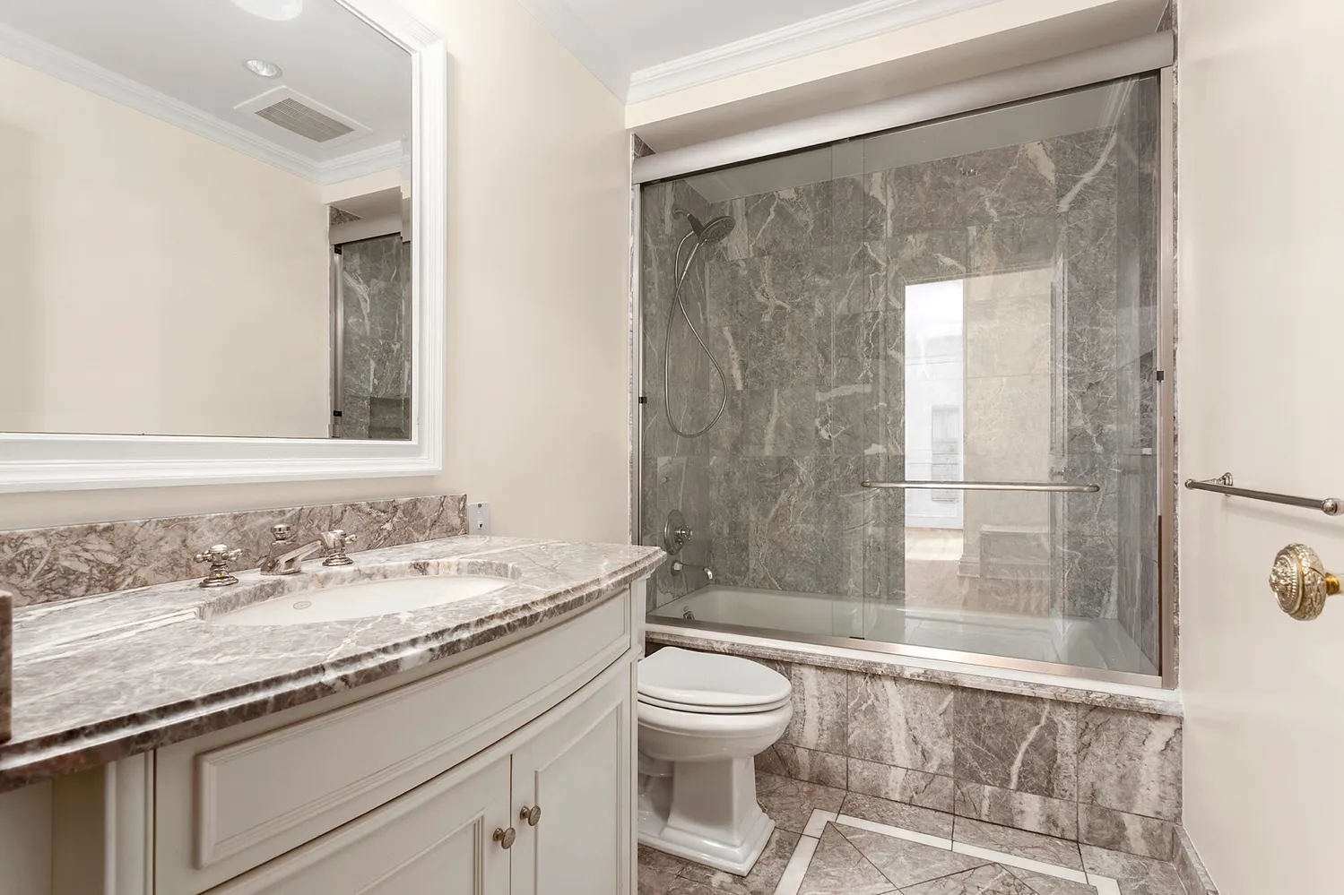a bathroom with a granite countertop sink a toilet a mirror and shower