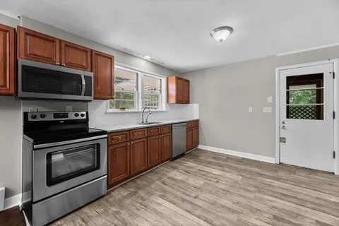 a kitchen with stainless steel appliances granite countertop a stove microwave and sink