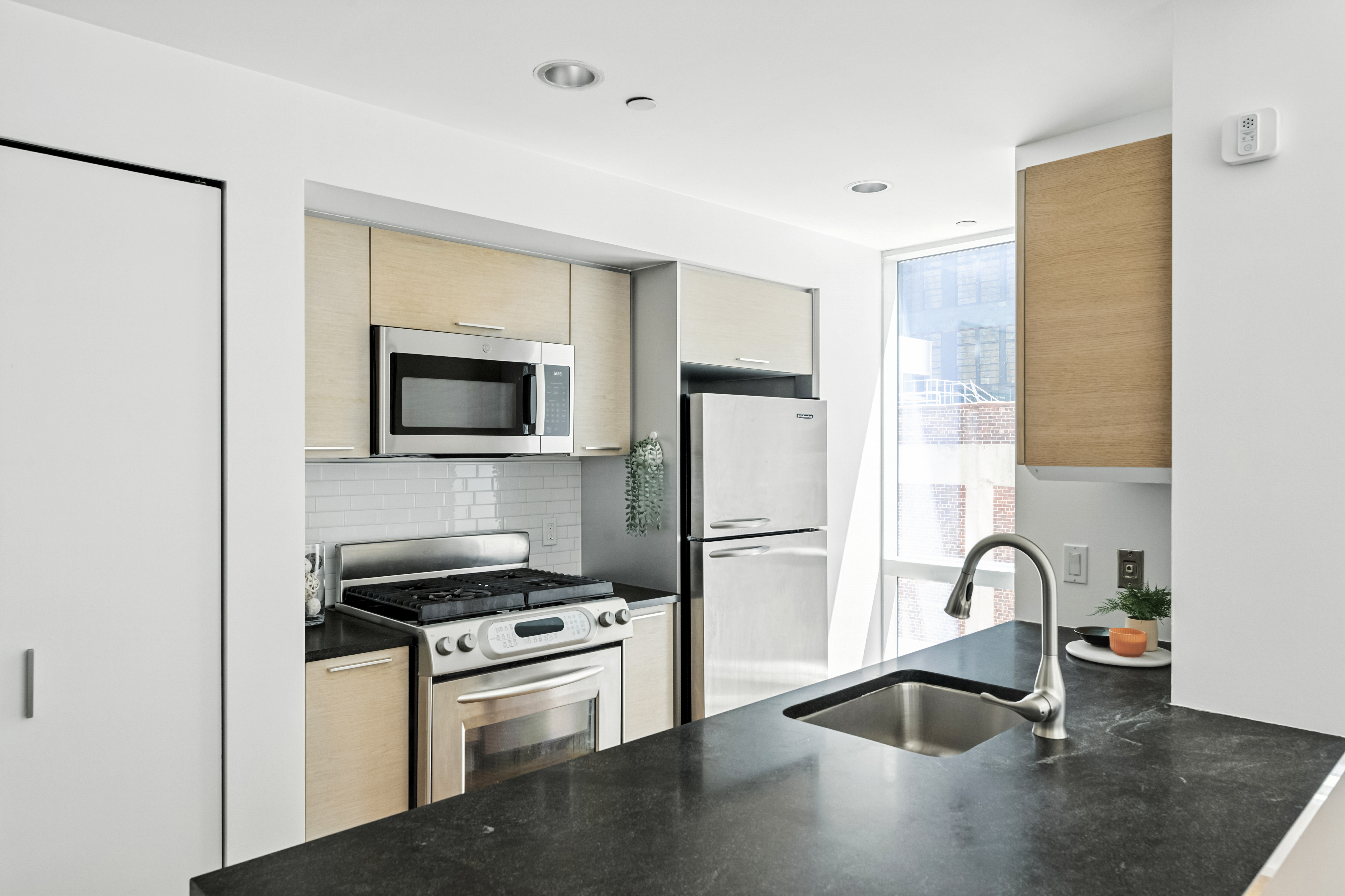 350 West 42nd Street, Unit 6K Manhattan, NY 10036 - Photo 4 of 13 a kitchen with a refrigerator and a sink
