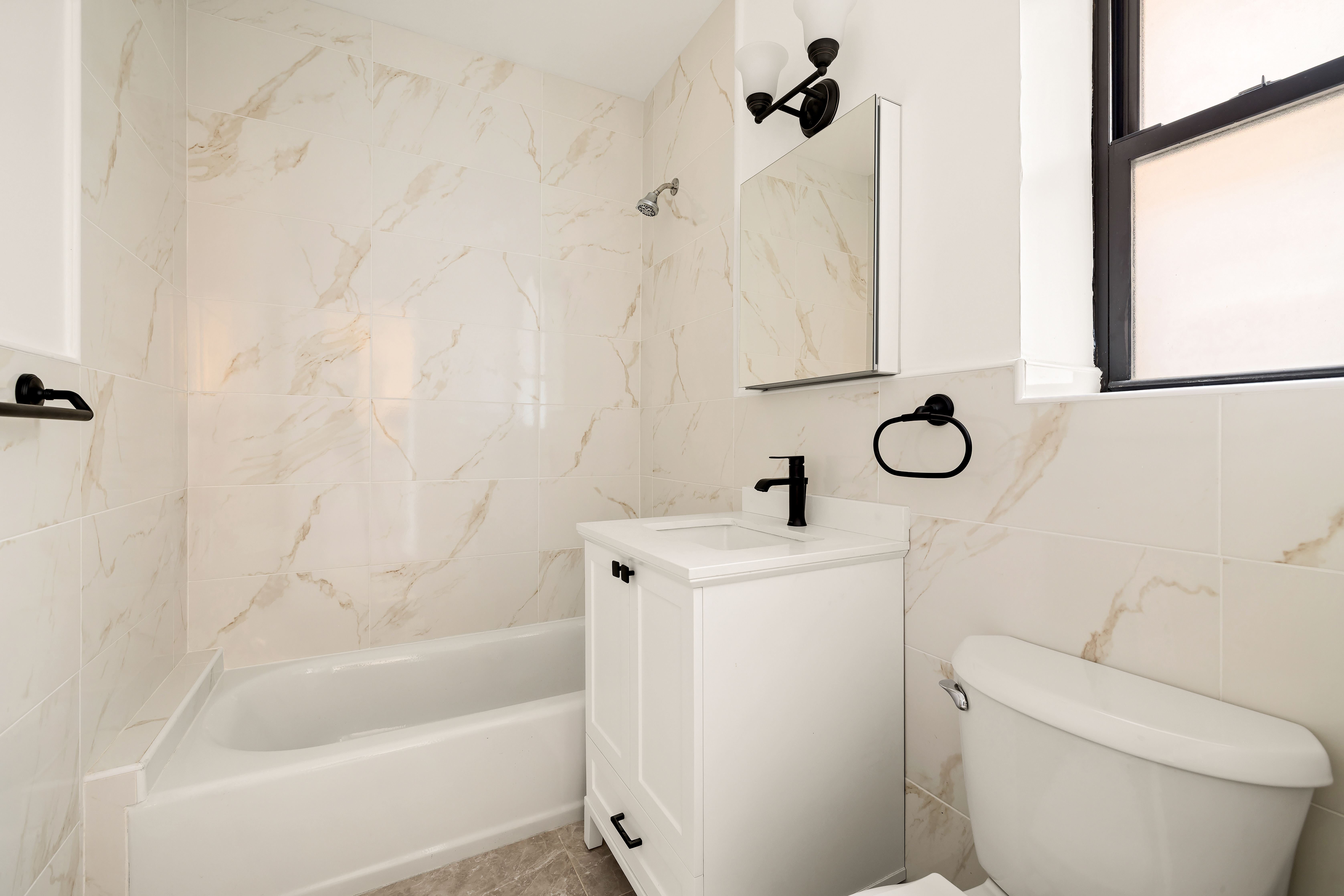 47-39 40th Street, Unit 1B Queens, NY 11104 - Photo 9 of 15 a bathroom with a sink a toilet and shower