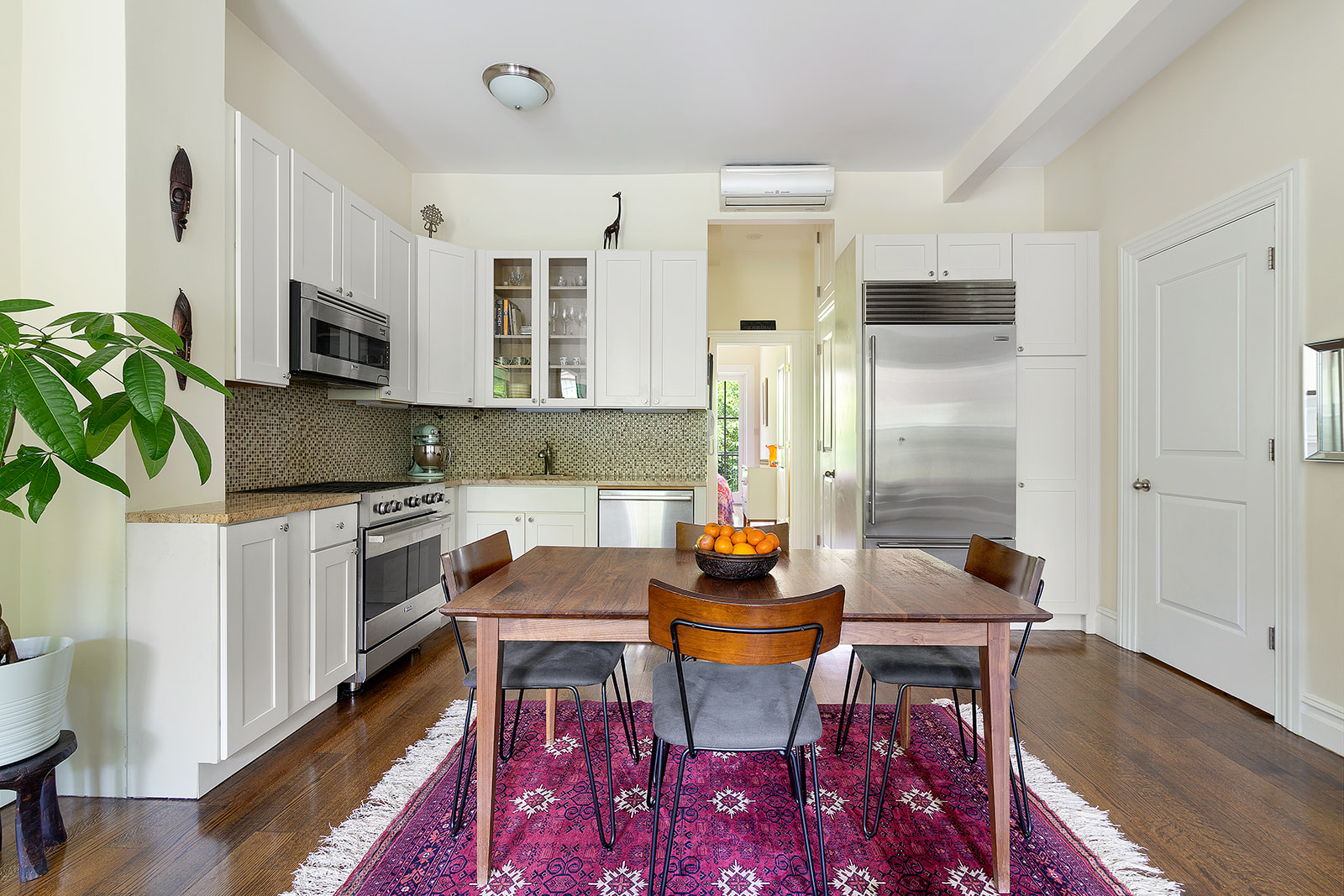 143 Bergen Street, Unit 201 Brooklyn, NY 11217 - Photo 3 of 10 a kitchen with stainless steel appliances granite countertop a stove a sink dishwasher a dining table and chairs with wooden floor