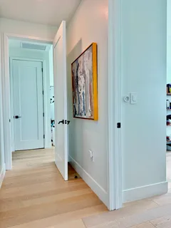 a view of a hallway with wooden floor and closet