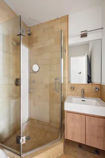 a bathroom with a shower sink and mirror