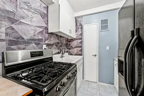 a stove top oven sitting inside of a kitchen