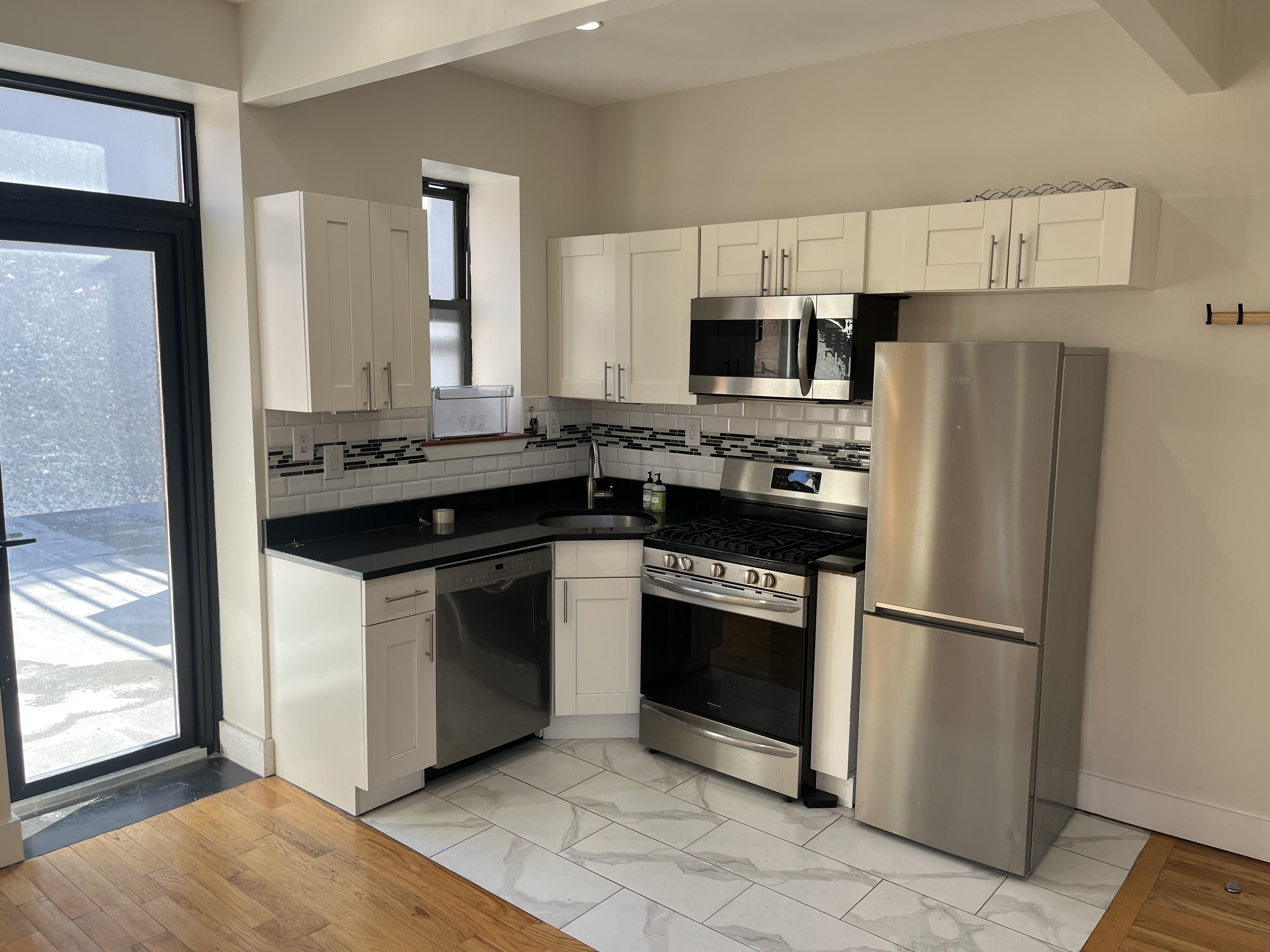 610 Monroe Street, Unit 2R Brooklyn, NY 11221 - Photo 2 of 6 a kitchen with stainless steel appliances granite countertop a refrigerator a stove a sink and a microwave