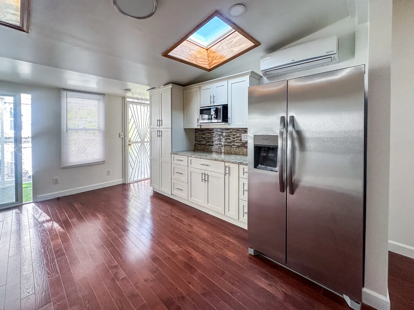 a kitchen with granite countertop a refrigerator and a stove top oven