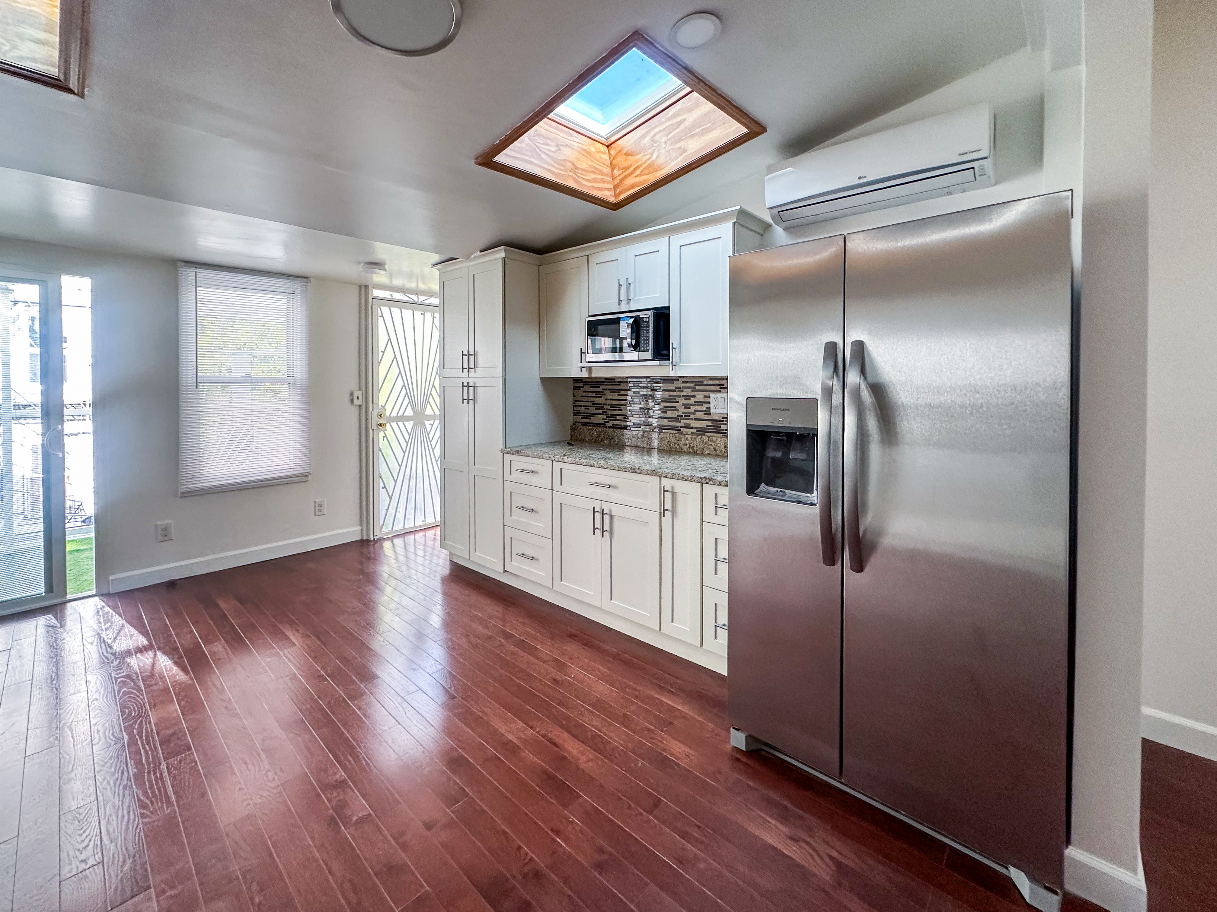 a kitchen with granite countertop a refrigerator and a stove top oven