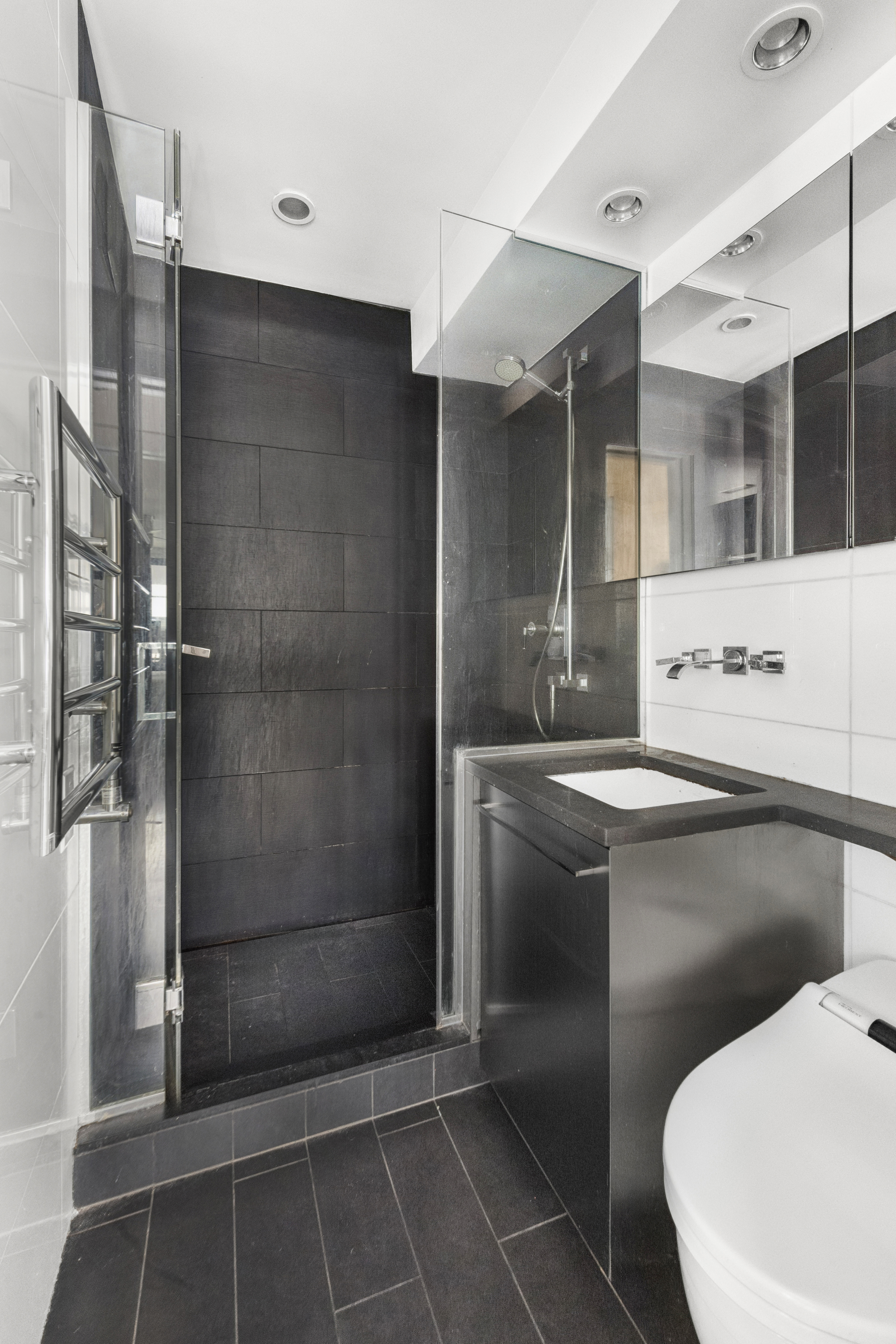 235 East 57th Street, Unit 5D Manhattan, NY 10022 - Photo 7 of 10 a bathroom with a shower and a sink