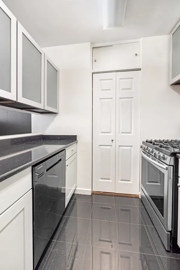 a kitchen with white cabinets and stainless steel appliances