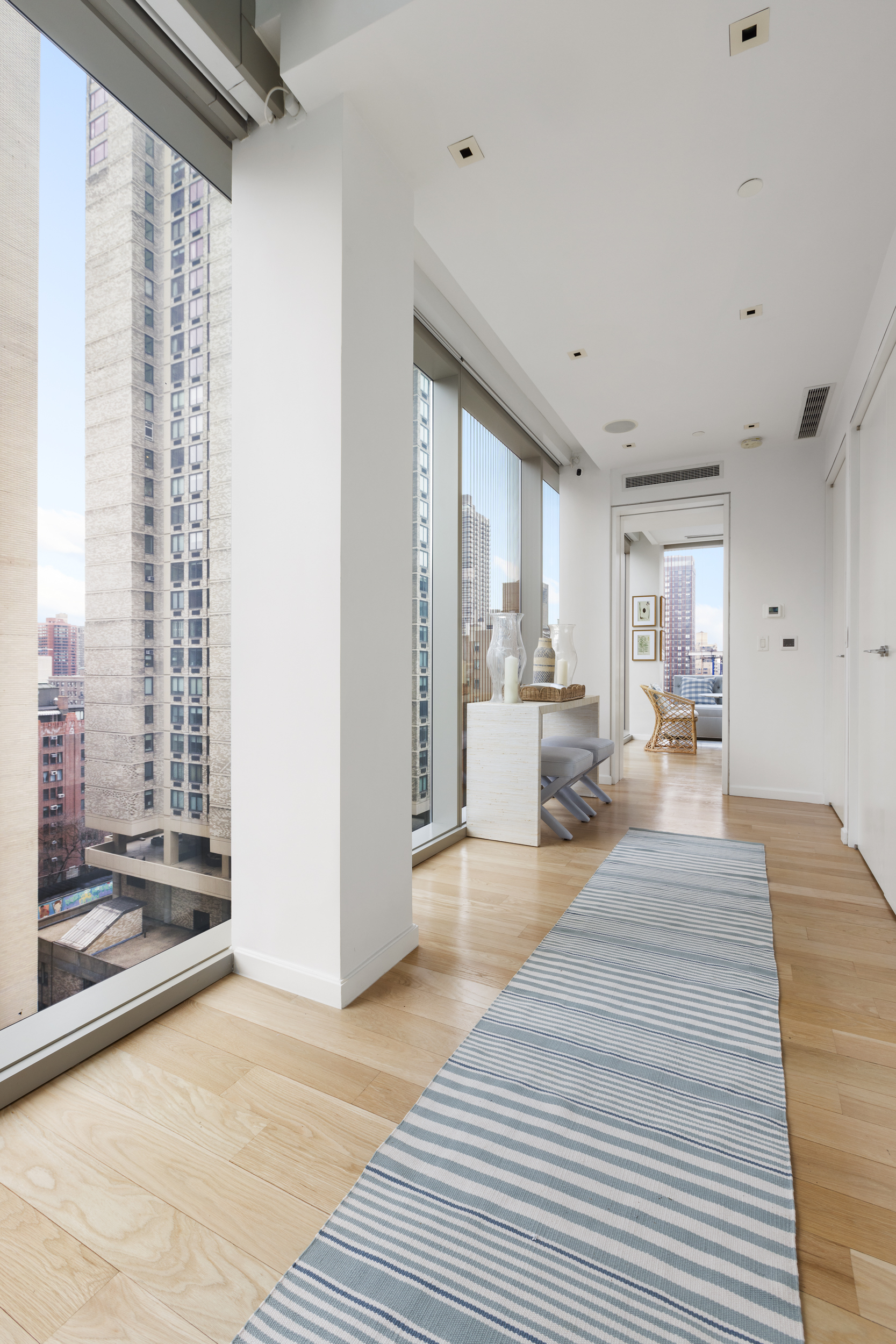 1055 Park Avenue, Unit PH Manhattan, NY 10028 - Photo 6 of 19 a large room with wooden floor and furniture