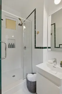a bathroom with a granite countertop sink a toilet and shower
