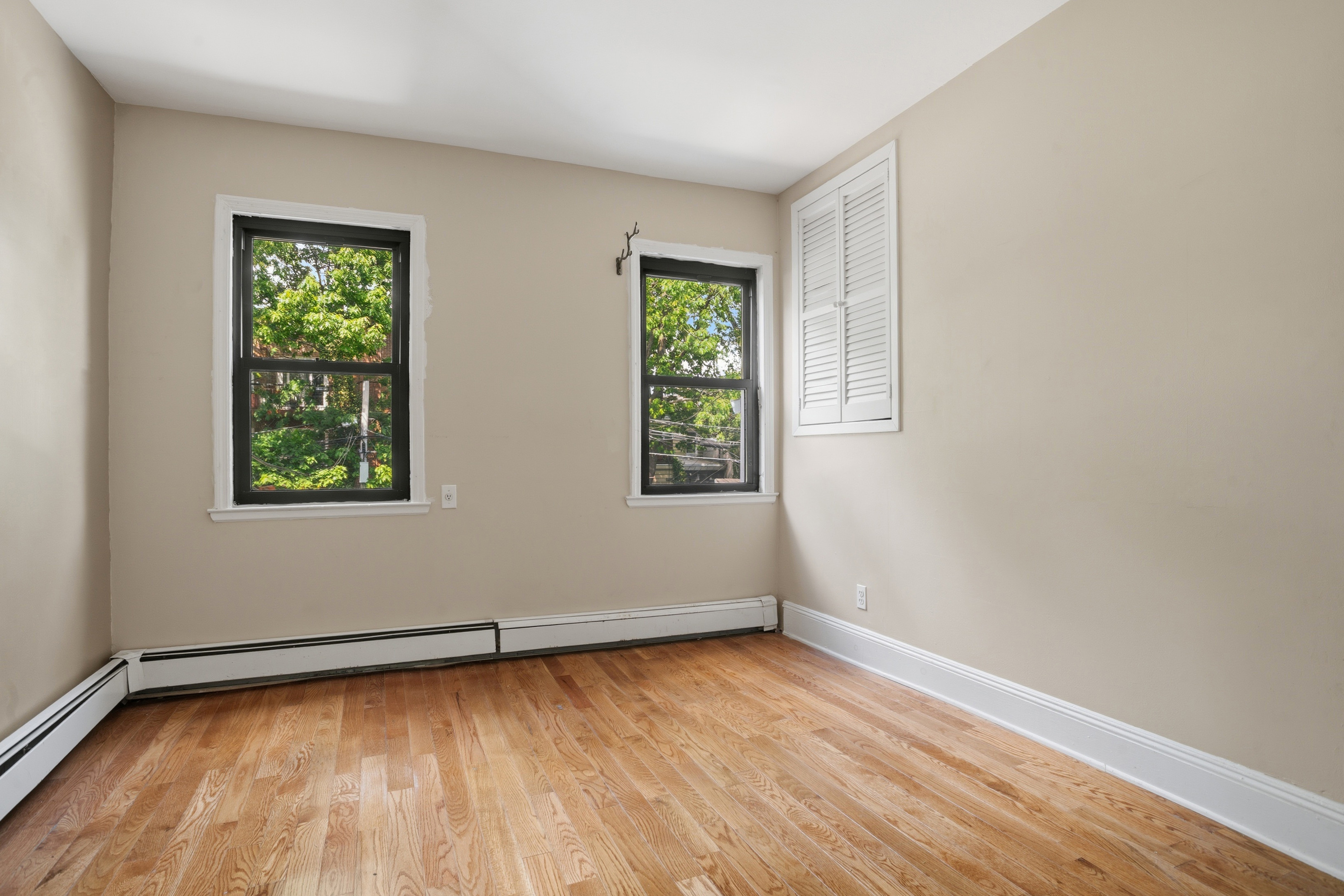 417 A 18th Street Brooklyn, NY 11215 - Photo 8 of 16 an empty room with wooden floor and windows
