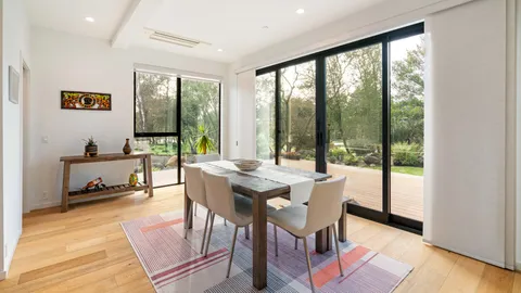 a dining room with furniture a rug and a floor to ceiling window