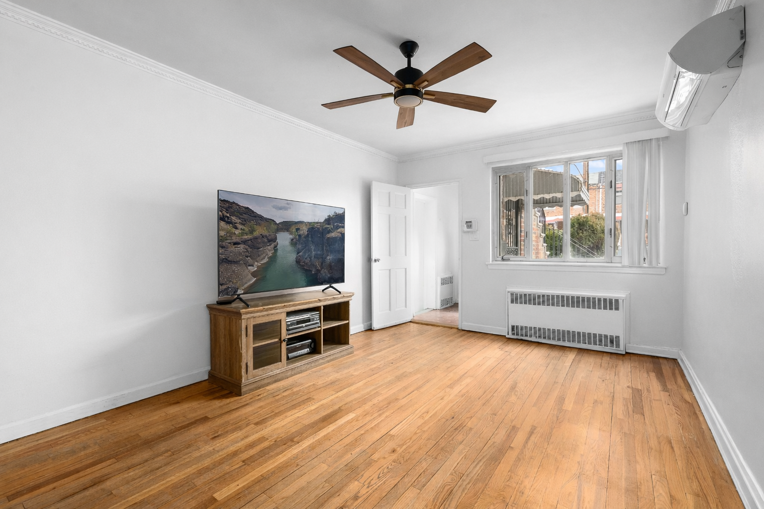 1268 East 52nd Street Brooklyn, NY 11234 - Photo 2 of 13 wooden floor in an empty room with a window