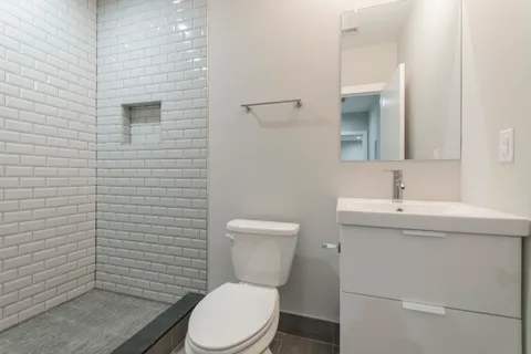 a bathroom with a toilet a sink and mirror