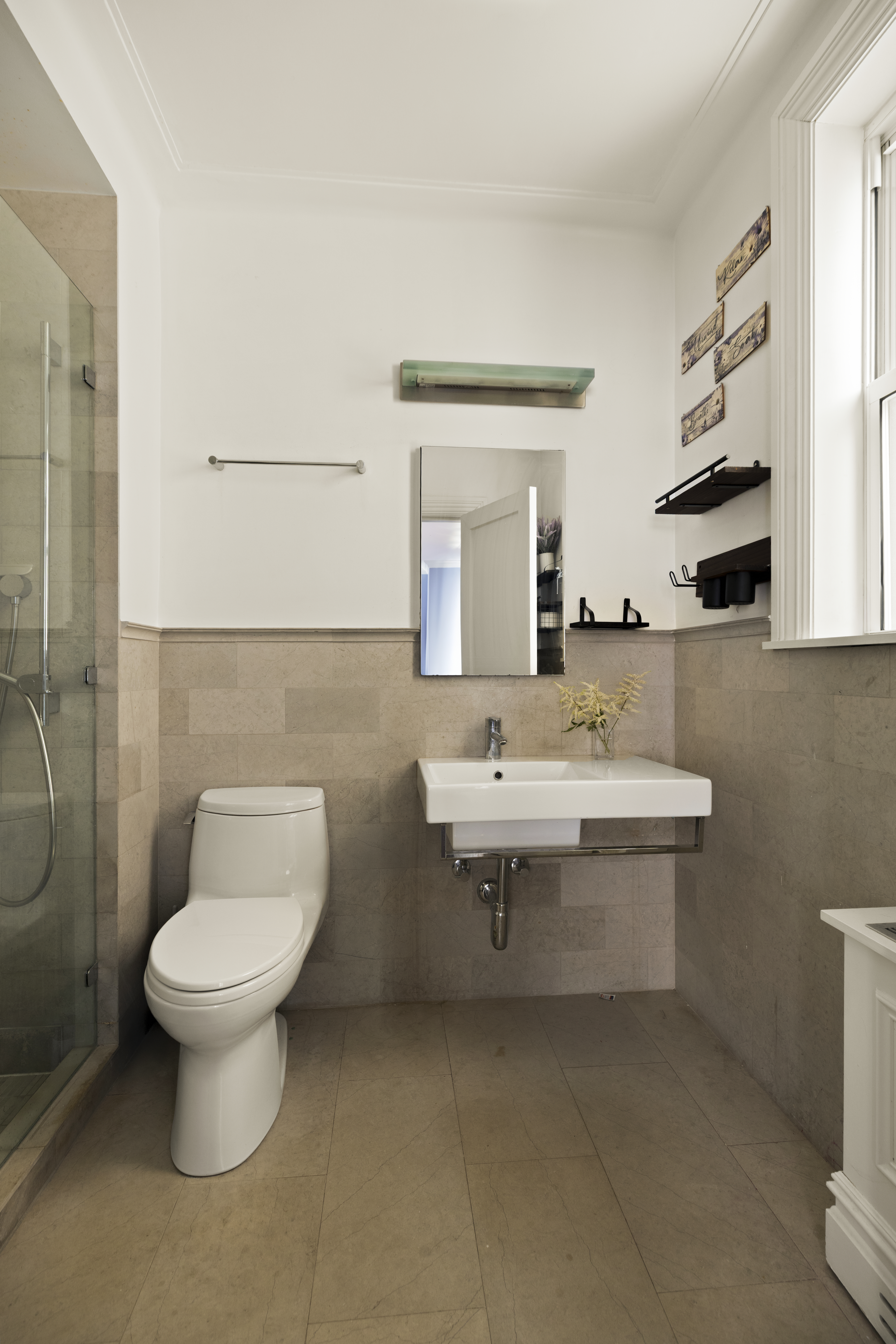 1158 5th Avenue, Unit 4A Manhattan, NY 10128 - Photo 11 of 24 a bathroom with a toilet sink and mirror