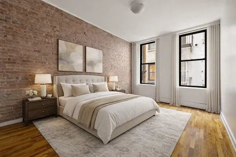 a bedroom with a bed wooden floor and window
