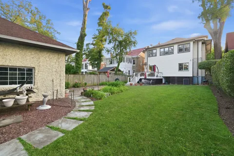 a view of a house with backyard sitting area and garden